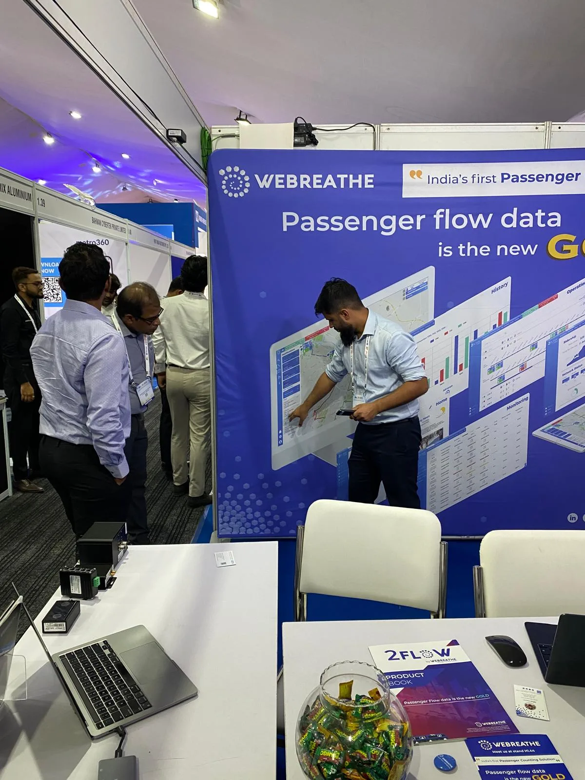 Visitors examining the WEBREATHE booth and equipment